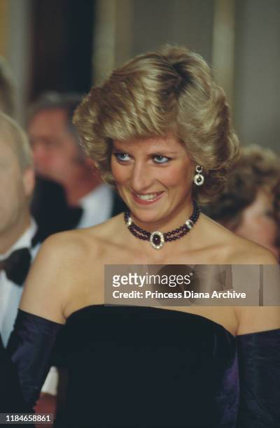 Diana, Princess of Wales attends the opera in Munich, Germany, wearing a purple strapless gown by Catherine Walker, November 1987.