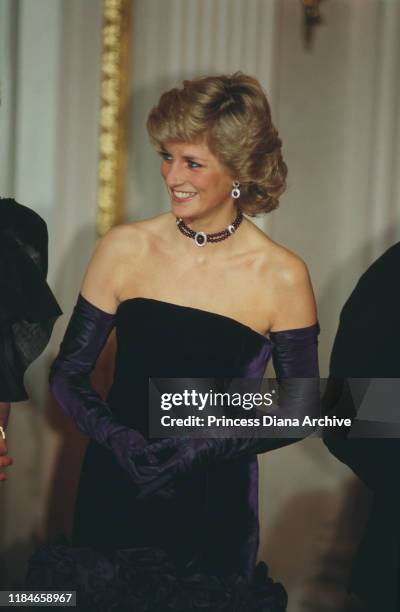 Diana, Princess of Wales attends the opera in Munich, Germany, wearing a purple strapless gown by Catherine Walker, November 1987.