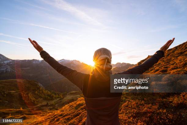 back view woman with arms wide open in mountain sunset - motivation stock pictures, royalty-free photos & images