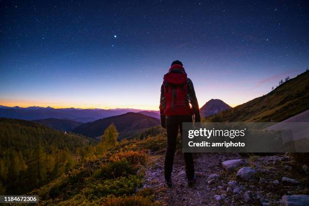 solo-reisender hoch oben in den bergen mit sternenhimmel - astronomie stock-fotos und bilder