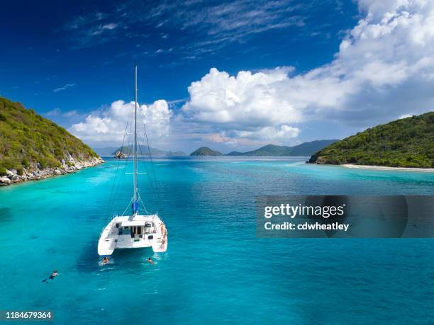 catamaran anchored with peope relaxing by lovango cay, virgin islands - caribbean dream stock pictures, royalty-free photos & images