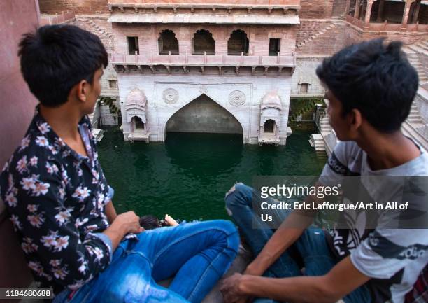 Indian boys looking at toorji ka Jhalra stepwell, Rajasthan, Jodhpur, India on July 20, 2019 in Jodhpur, India.