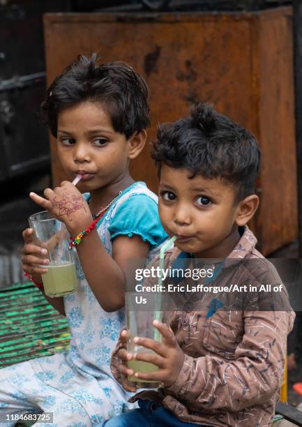 Indian children drinking lemonade in the street with plastic straws, Rajasthan, Bundi, India on July 15, 2019 in Bundi, India.