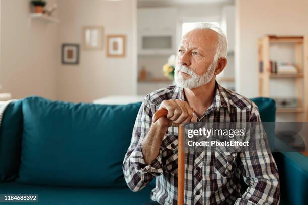 portret van senior man thuis - walking cane stockfoto's en -beelden