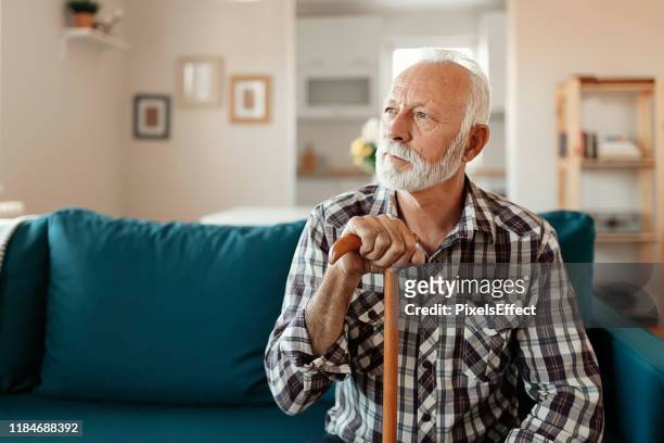 portrait of senior man at home - walking stick stock pictures, royalty-free photos & images