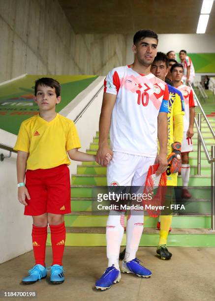 Shohrukh Qirghizboev of Tajikistan stands in the tunnel with a player escort before the FIFA U-17 World Cup Brazil 2019 group E match between Spain...
