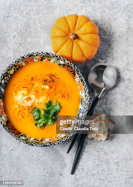 bowl of squash soup on gray background - kürbissuppe stock-fotos und bilder