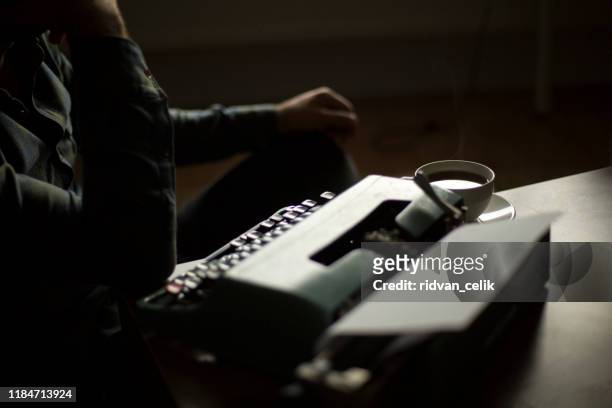 thoughtful bearded stylish writer typing on typewriter - poet stock pictures, royalty-free photos & images