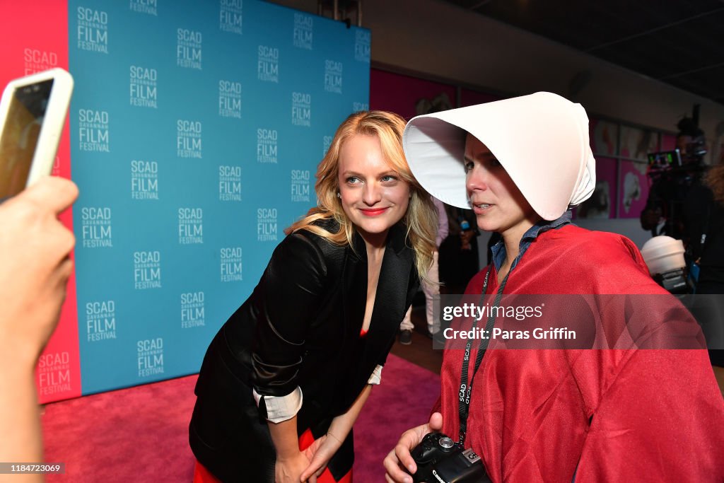 Actress Elisabeth Moss poses with a festival goer during 22nd SCAD
