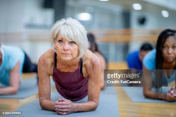 Senior Woman in Fitness Class in a Plank Pose stock photo