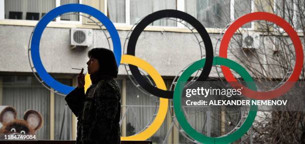 Woman smokes in front of the Russian Olympic Committee headquarters in Moscow on November 26, 2019. - Russia's anti-doping chief said on November 26,...