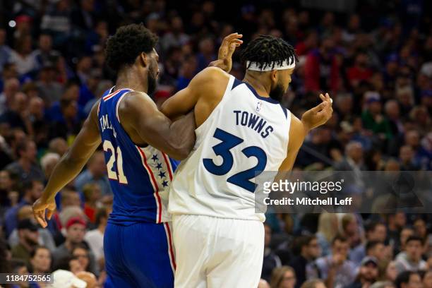 Joel Embiid of the Philadelphia 76ers gets tangled up with Karl-Anthony Towns of the Minnesota Timberwolves in the third quarter at the Wells Fargo...