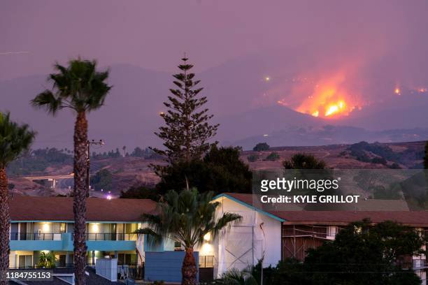The Cave fire burns a hillside above houses in Santa Barbara, California on November 26, 2019. The wind-driven brush fire that started late on...