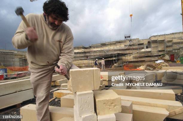 Un tailleur des pierre travaille le 19 janvier 2005 à la restauration des remparts nord-ouest du château ducal à Caen. Ce chantier a nécessité la...