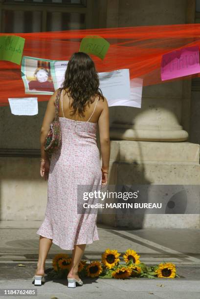 Une personne lit les messages qui ont été accrochés en hommage à Marie Trintignant et à toutes les victimes de violence conjugale, le 09 août 2003...