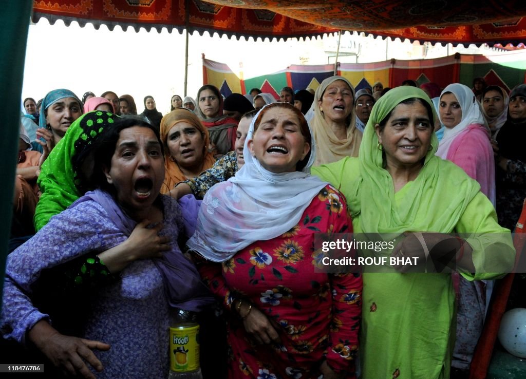 Relatives mourn near the body of a polic