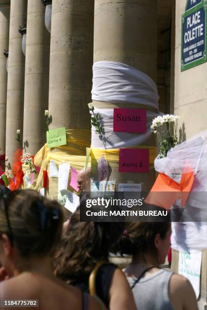 Des personnes lisent les messages qui ont été accrochés en hommage à Marie Trintignant et à toutes les victimes de violence conjugale, le 09 août...