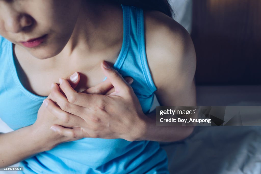 Close-up of woman having suffering from chest pain or heart attack.