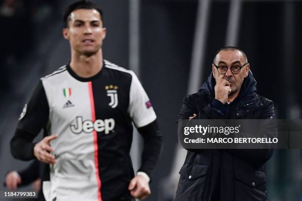 Juventus' Italian coach Maurizio Sarri looks on as Juventus' Portuguese forward Cristiano Ronaldo runs past during the UEFA Champions League Group D...