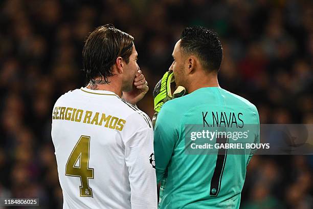 Real Madrid's Spanish defender Sergio Ramos talks to Paris Saint-Germain's Costa Rican goalkeeper Keylor Navas during the UEFA Champions League group...