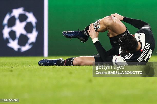 Juventus' Portuguese forward Cristiano Ronaldo lies on the pitch after being tackled during the UEFA Champions League Group D football match Juventus...