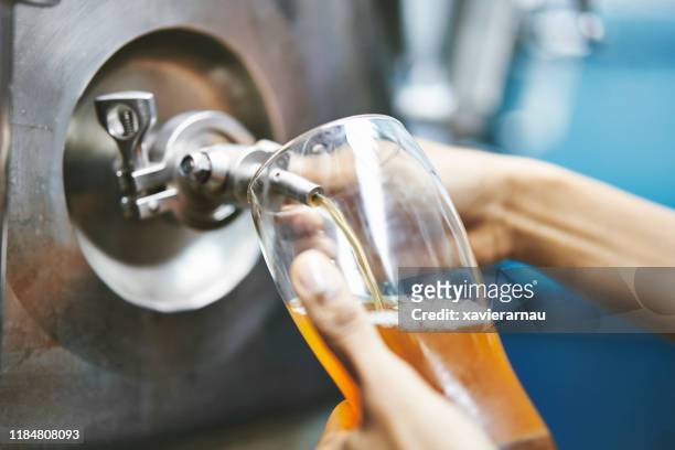 south american craft brewer drawing beer sample from vat - beer brewery stock pictures, royalty-free photos & images