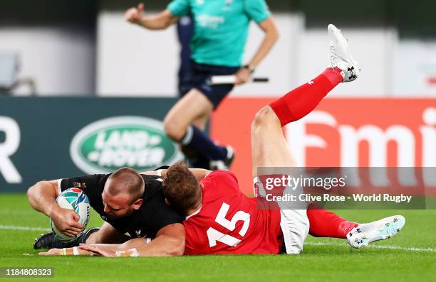 Joe Moody of New Zealand touches down to score his team's first try under pressure from Hallam Amos of Wales during the Rugby World Cup 2019 Bronze...