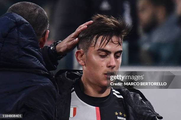 Juventus' Italian coach Maurizio Sarri congratulates Juventus' Argentine forward Paulo Dybala as leaves the pitch to be substituted during the UEFA...