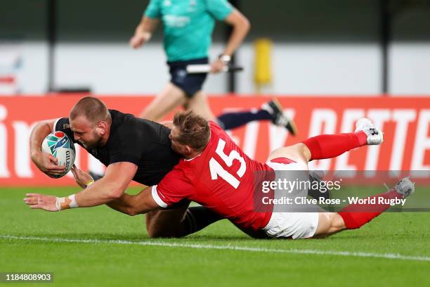 Joe Moody of New Zealand touches down to score his team's first try under pressure from Hallam Amos of Wales during the Rugby World Cup 2019 Bronze...