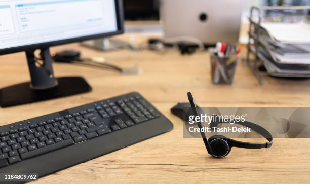 dispositivo auricolare call center presso office desk per il concetto di telemarketing hotline - customer service documents foto e immagini stock