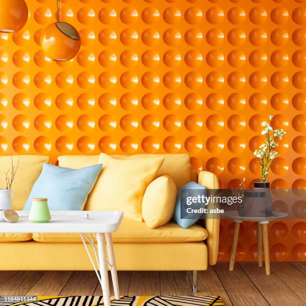 colorful sofa with geometric orange wall - bright stock pictures, royalty-free photos & images