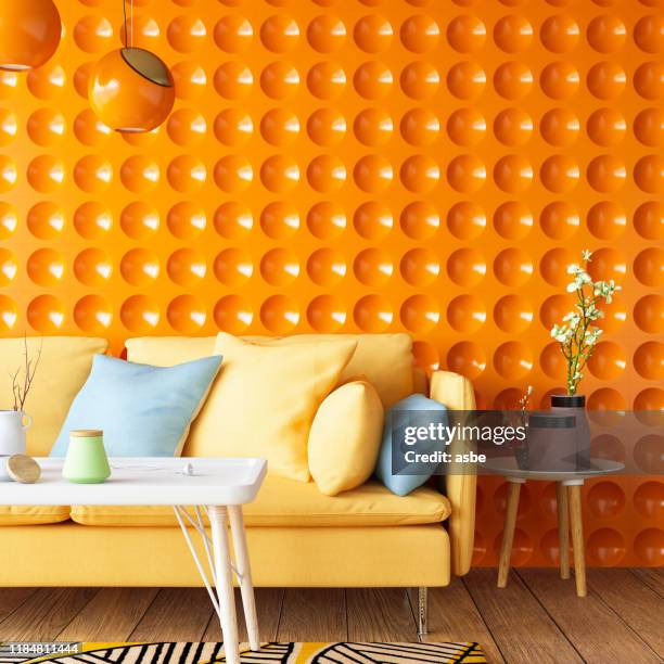 colorful sofa with geometric orange wall - bright room stock pictures, royalty-free photos & images