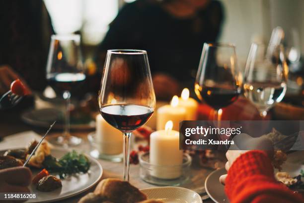 amigos disfrutando de una cena de navidad juntos - vino tinto fotografías e imágenes de stock