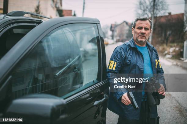 an old fbi agent uses a gun in action - fbi stock pictures, royalty-free photos & images