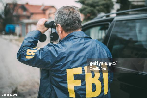 an old fbi agent uses binoculars - fbi stock pictures, royalty-free photos & images