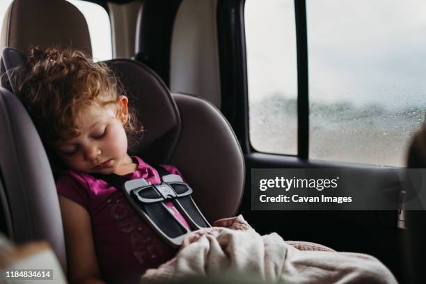 young girl sleeping in car seat while it rains outside - girl rain night stock pictures, royalty-free photos & images