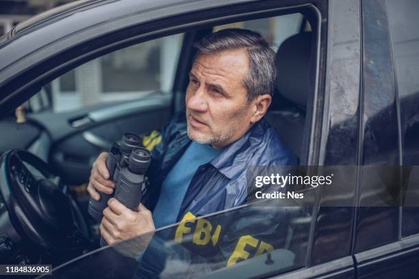 an old fbi agent uses binoculars for observation - fbi vehicle stock pictures, royalty-free photos & images