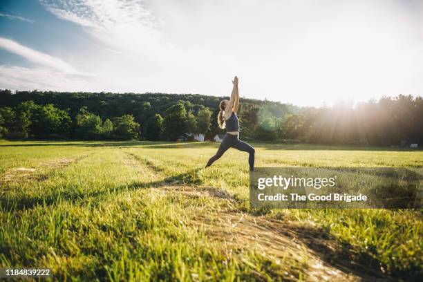 mature woman practicing yoga in field - yoga outdoor stockfoto's en -beelden