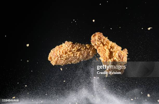 crispy chicken wing flying in mid air captured with high speed sync."n - gefrituurde kip stockfoto's en -beelden