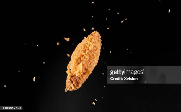crispy chicken wings flying in mid air captured with high speed sync."n - movimiento rápido fotografías e imágenes de stock