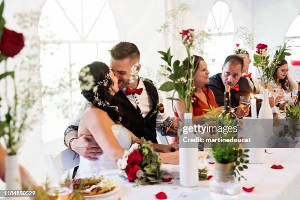 newlyweds kissing at the table of honour at wedding reception. - wedding food stock pictures, royalty-free photos & images