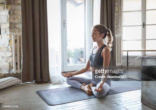 young sporty woman practicing yoga - lotus position imagens e fotografias de stock