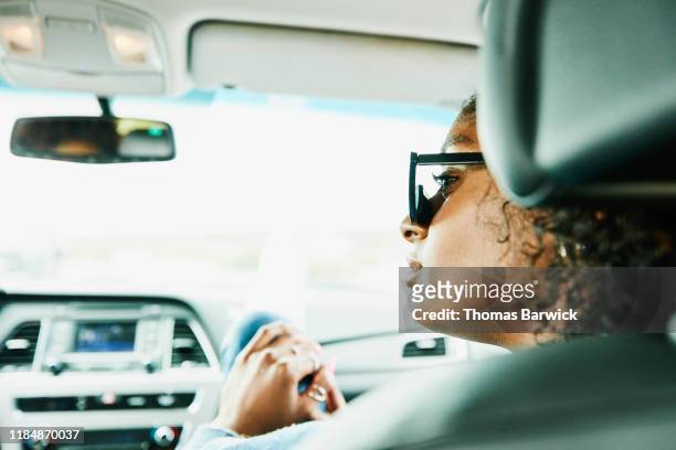 portrait of woman sitting in passenger seat of car - passenger seat foto e immagini stock