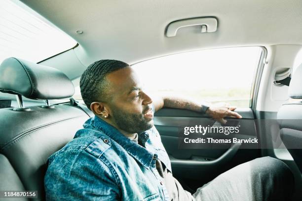 smiling man riding in back seat of car - comfortable car stock pictures, royalty-free photos & images