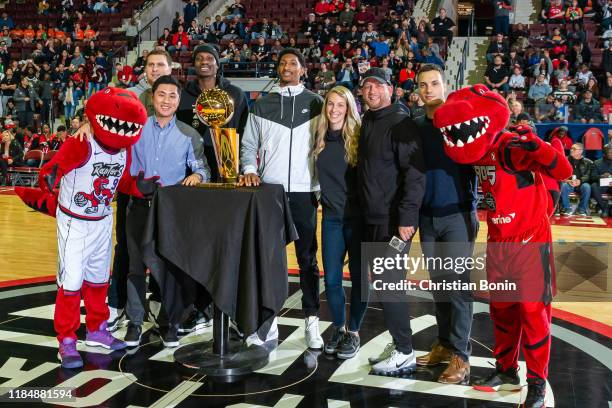 Toronto Raptors Head Coach Nick Nurse poses for a picture with past 905 players and staff and the NBA Championship trophy during a time out at the...