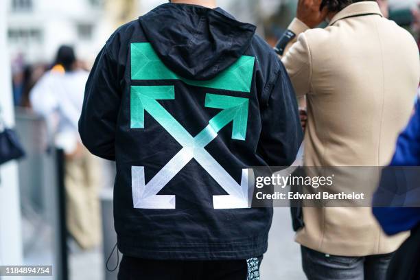 Guest wears a black hoodie with a green and white Off-White large logo, outside Off-White, during Paris Fashion Week - Womenswear Spring Summer 2020,...