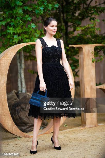 Laetitia Casta wears a black lace mesh dress with embroidery, outside Dior during Paris Fashion Week - Womenswear Spring Summer 2020, on September...