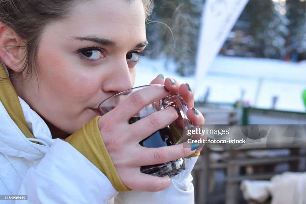 Beautiful young girl drinking mulled wine