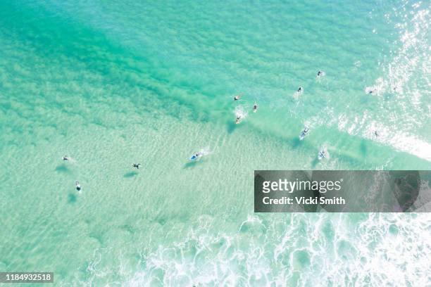 aerial point of view crystal clear ocean waters with people surfing - surfer australia stock-fotos und bilder