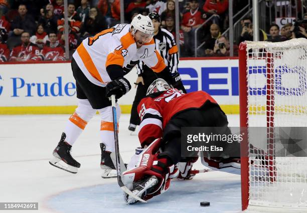 Sean Couturier of the Philadelphia Flyers scores the game winning goal as Mackenzie Blackwood of the New Jersey Devils is unable to make the save in...
